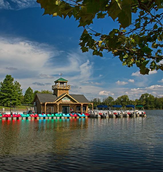 A boathouse with a dock next to it on a lake on a sunny day
