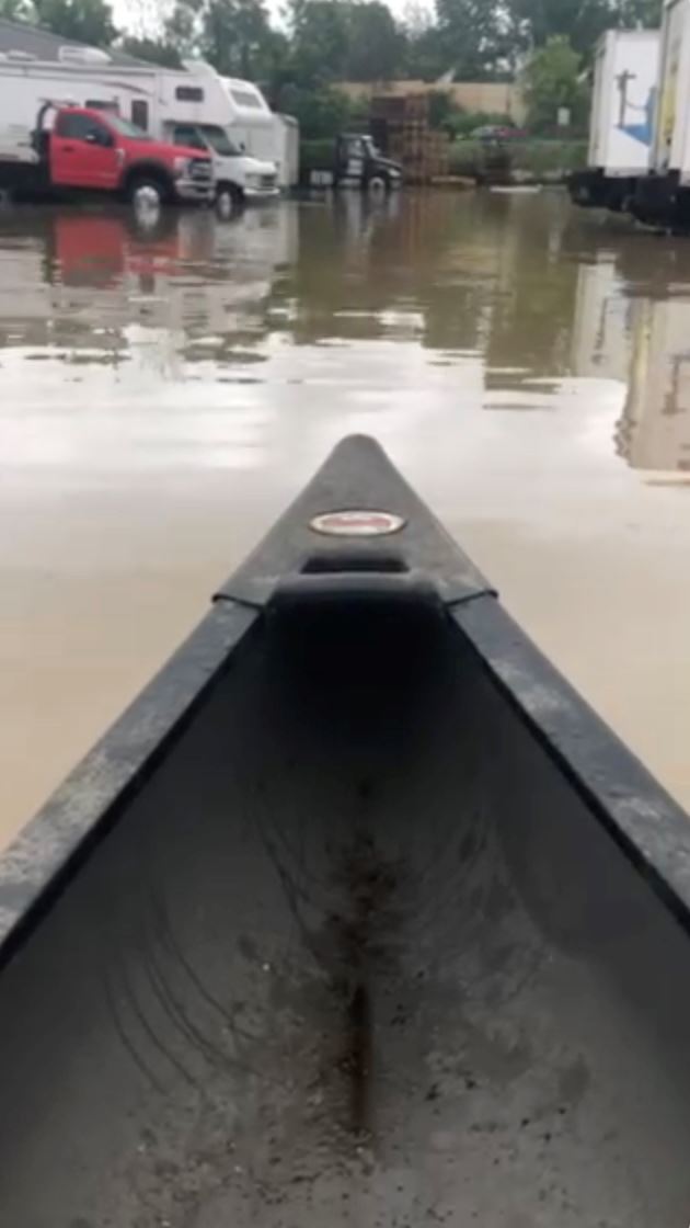 A business owner kayaks through his parking lot during the 2020 storm